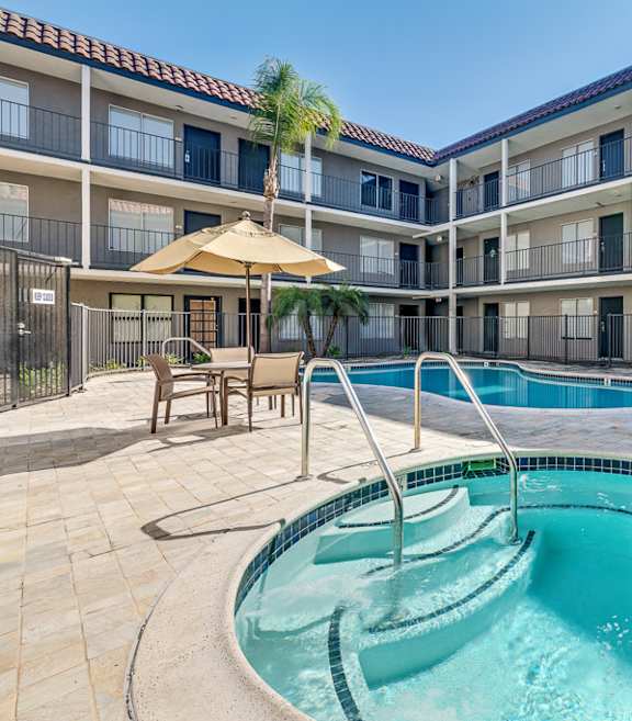 A swimming pool in a courtyard surrounded by apartment buildings.