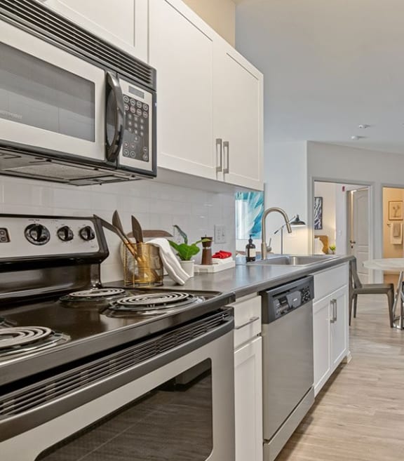 a kitchen with stainless steel appliances and white cabinets at Element Deer Valley in AZ 85027