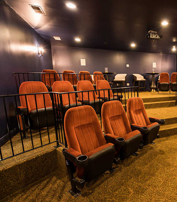 A row of orange seats in a dark room.
