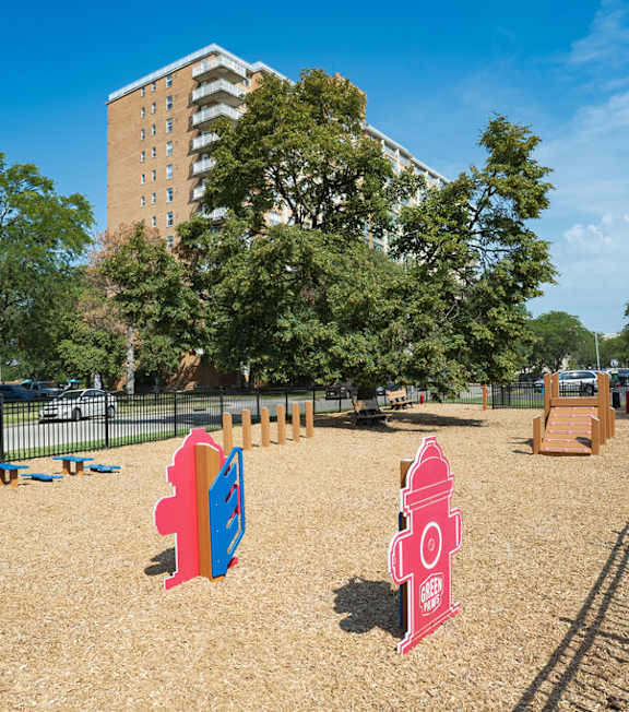 A playground with a red fire hydrant and a blue slide.