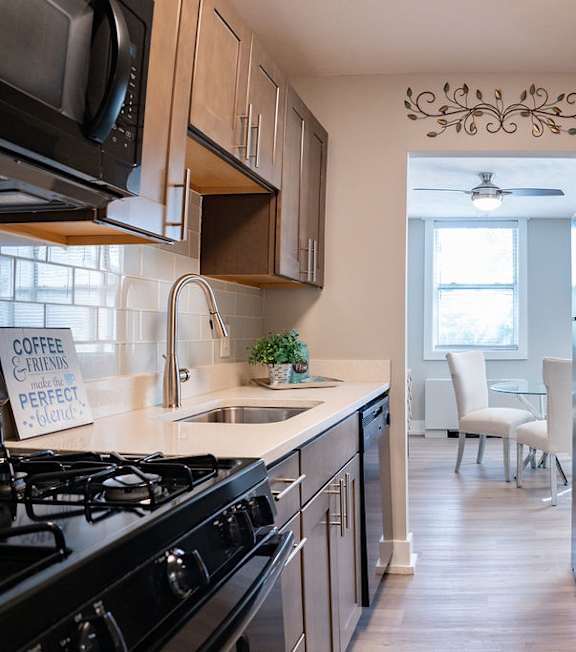A kitchen with a black refrigerator and a sign that says "coffee caramel perfect.".