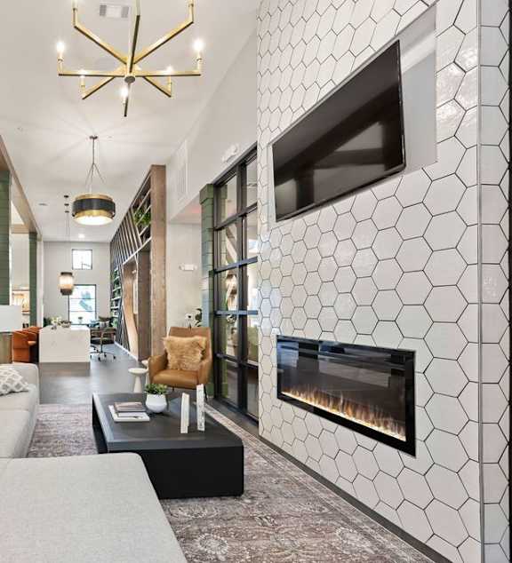A modern living room with a grey sofa and a fireplace.