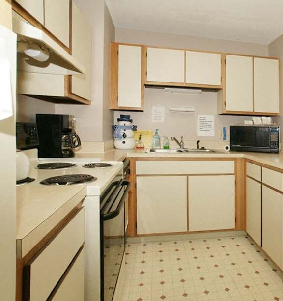 A kitchen with white appliances and wooden cabinets.