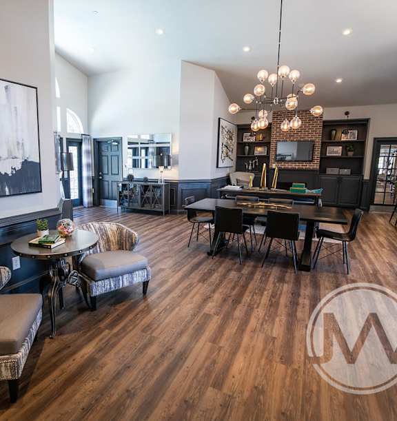A large room with a wooden floor and a large painting on the wall.