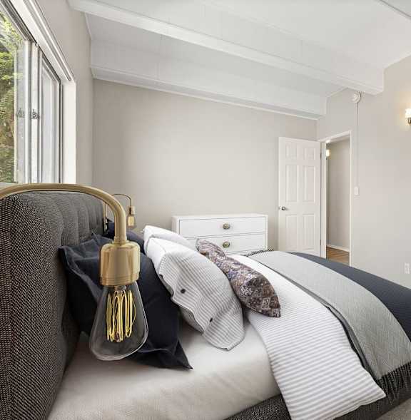 A bedroom with a bed, a chair, and a wardrobe.