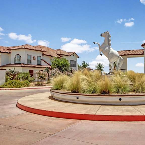 The entrance to Andalucia Villas that has a roundabout with a white house statue in the middle. 
