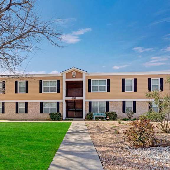 The front entrance to one of the apartment buildings at Golden Crest, with green space in front of it.