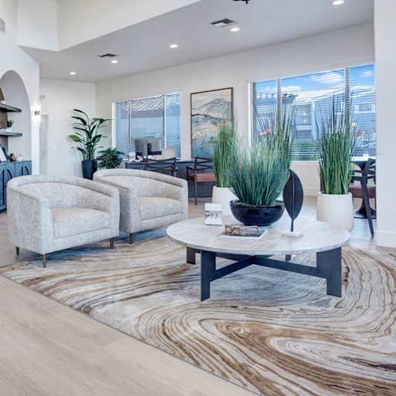 A living room with two couches and a coffee table with and office in the background at Pala Mesa Apartments. 