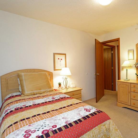 a white bedroom with a large bed and a window