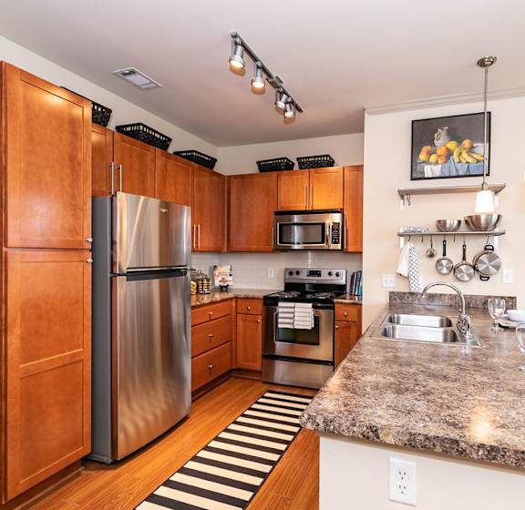 A kitchen with wooden cabinets and granite countertops. at Westmount at Ashwood Apartments, Atlanta, 30338