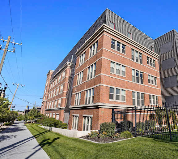 a tall brick building with a fence in front of it