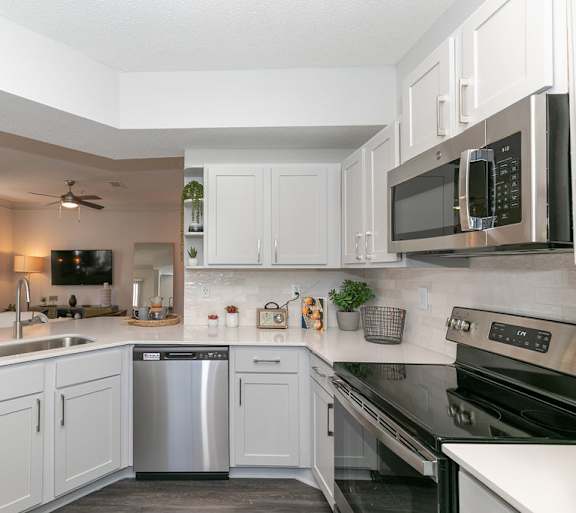 a kitchen with white cabinets and stainless steel appliances at Deerfield Village, Georgia