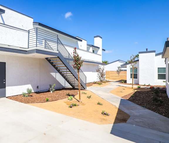 A modern kitchen with a dining area and a view of the balcony. at Hamilton Courtyard Apartments, Costa Mesa, CA, 92627