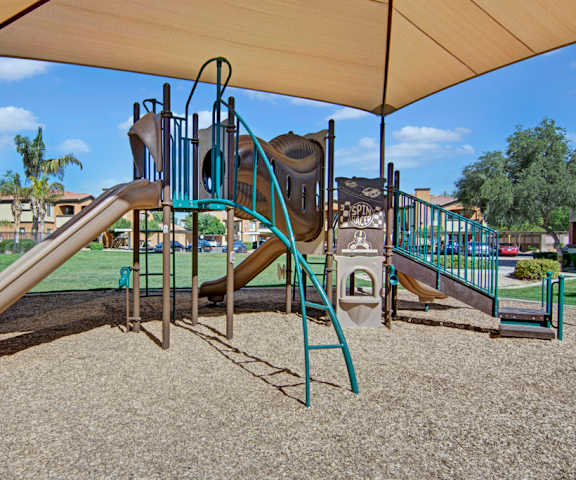 A playground with two slides and a climbing structure at Arezzo Apartments. 