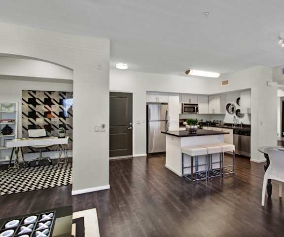 The dining room and kitchen of Artisan at Main Street Metro, fully furnished with black and white furniture. 