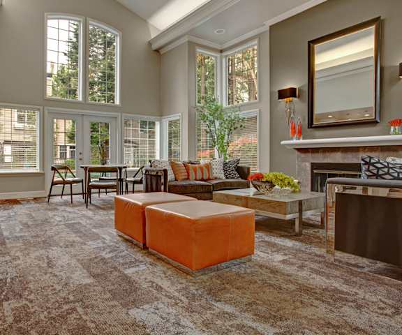 The resident lounge at Aspen Creek with couches, a fireplace, and a dining table in the background. 