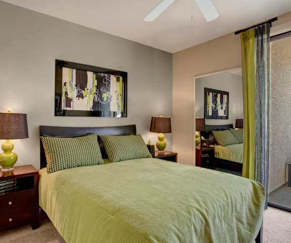 A bedroom with a bed and a ceiling fan at Aspen Terrace. 