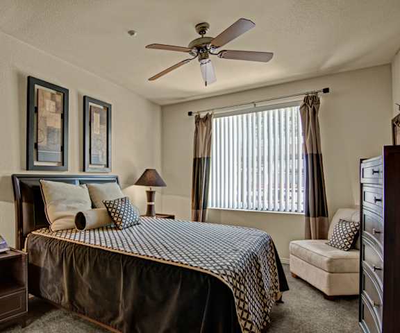 a bedroom with a bed and a ceiling fan