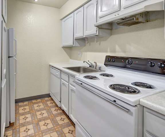 A kitchen with white appliances and counters at the Continental Apartment Homes. 