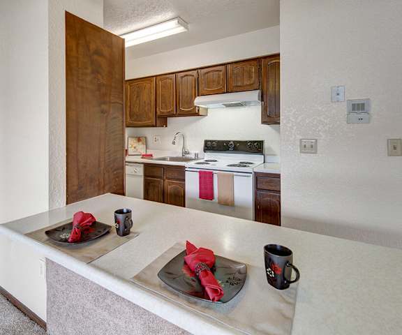 A kitchen with white appliances and counters at the Continental Apartment Homes. 