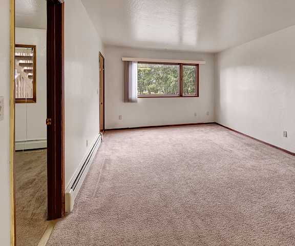 An empty bedroom with a window at Driftwood Apartments. 