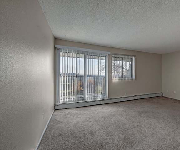 The living room of at Cedar Gardens with a door to the balcony. 