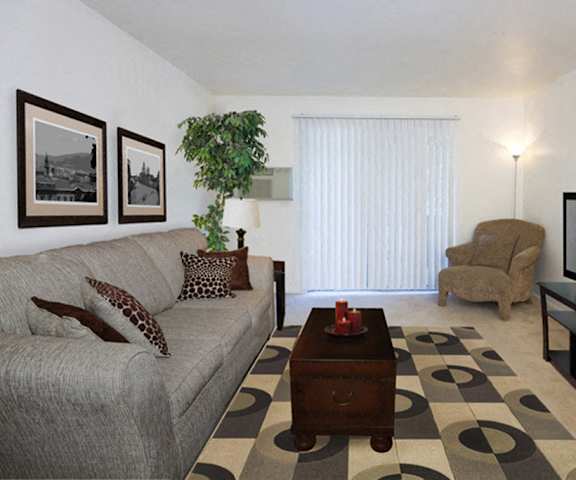 The living room with a couch, plush chairs, coffee table, decorations, a TV, and balcony at Hyde Park Apartments. 