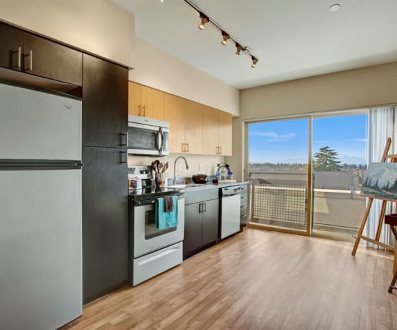 a kitchen with stainless steel appliances and a wooden floor