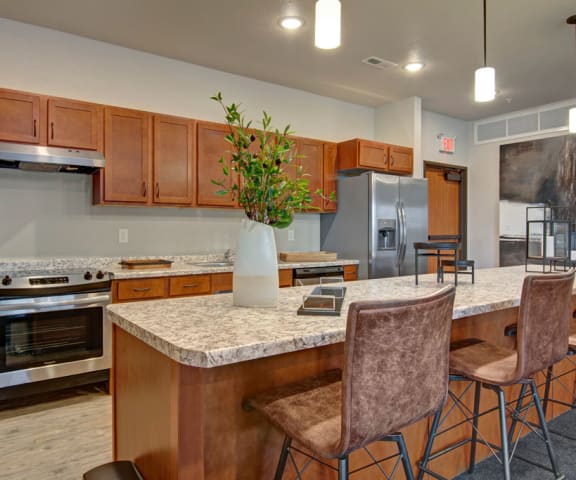 a kitchen with a large island with a breakfast bar and stainless steel appliances