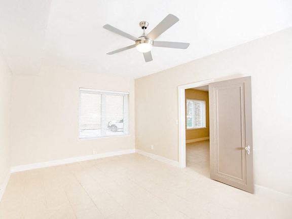 A room with a ceiling fan and a window.