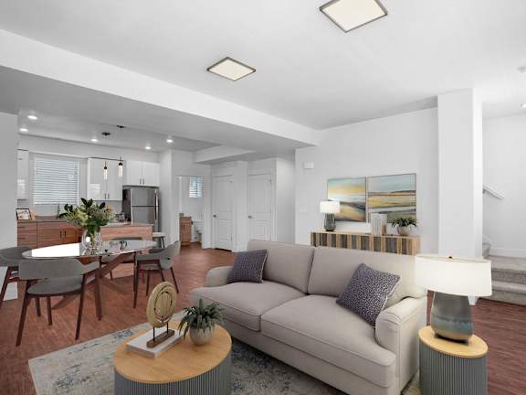 A modern living room with a grey sofa, wooden coffee table, and a large painting on the wall.