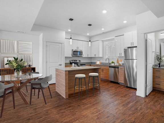 A modern kitchen with a wooden floor and stainless steel appliances.