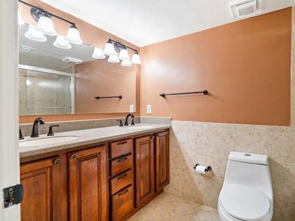 A bathroom with brown cabinets and a white toilet.