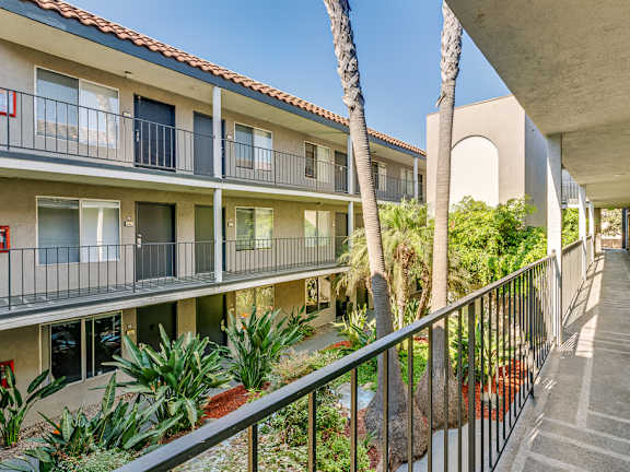 a balcony view of a building with palm trees