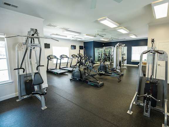 A gym with a variety of equipment including a leg press machine.