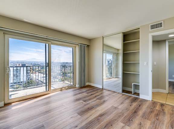 an empty living room with wood floors and a large window