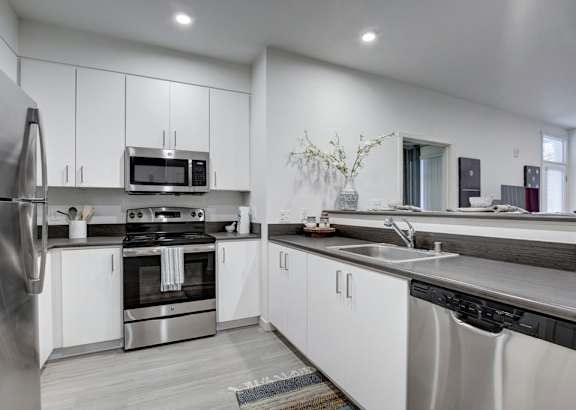 A modern kitchen with stainless steel appliances and white cabinets.