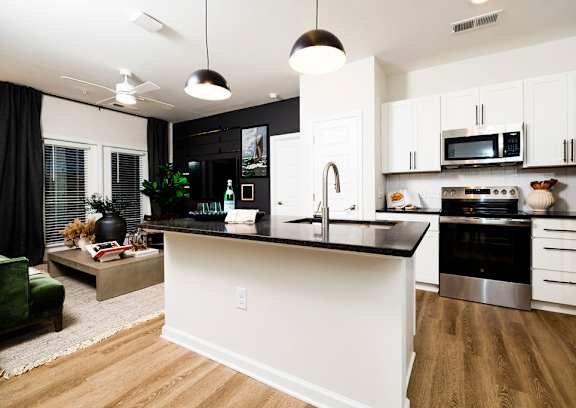 a reception area with a white desk and a logo on the wall at Evolve St. James Apartment Homes Apartments, Southport, NC, 28461