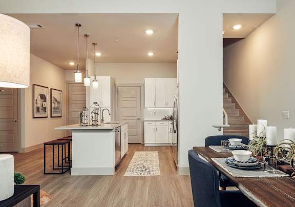 A modern kitchen with a dining table set for two.