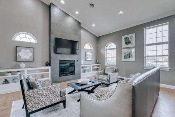 A living room with a grey couch and a fireplace.