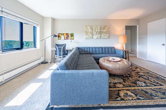 a living room with a blue couch and a round table