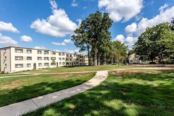 A sunny day at a residential area with apartment buildings and a walking path.