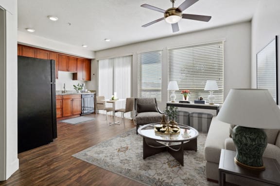 a living room and kitchen with a ceiling fan