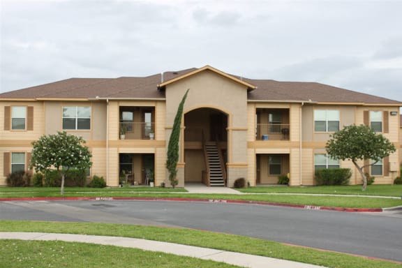 an apartment building with a sidewalk in front of it