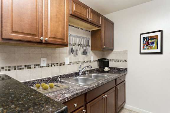 A kitchen with a black countertop and white cabinets.