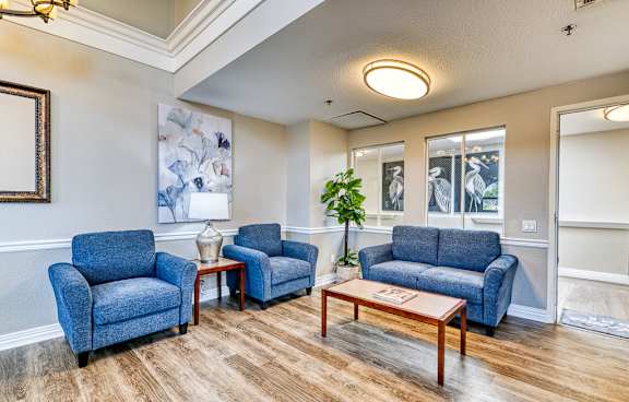 A living room with blue chairs and a wooden coffee table.