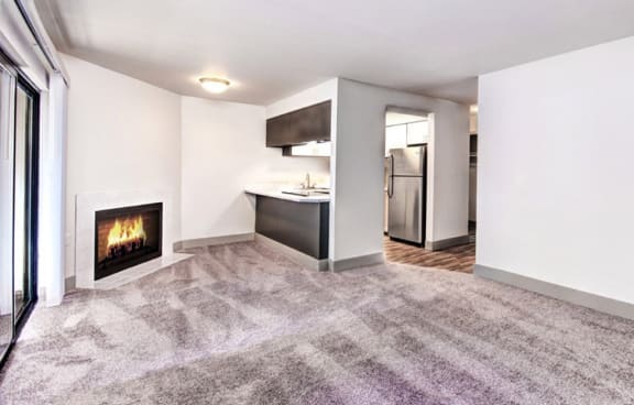 A modern living room with a fireplace and grey carpet. at Autumn Village, Washington, 98354