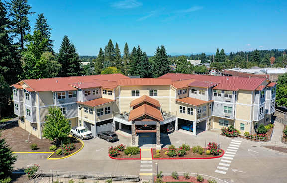 A large apartment complex with a parking lot in front.