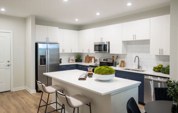 a kitchen with a white counter top and a stainless steel refrigerator
