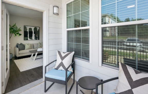a porch with a chair and a table and windows